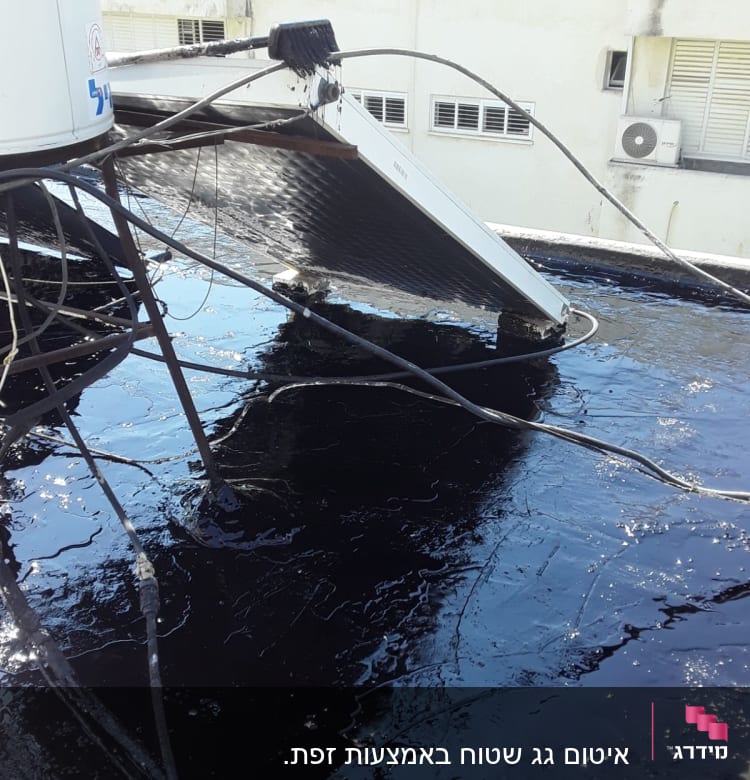 גג אטום בזפת עם קולטי שמש וחוטים